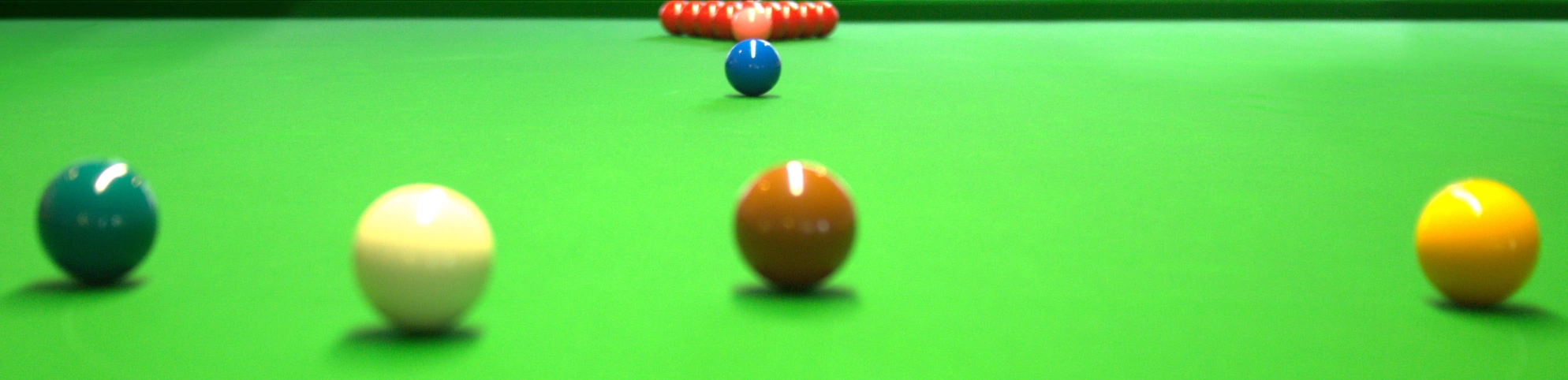 Grünes Tuch eines Snooker-Tischs mit fast allen Kugeln sichtbar